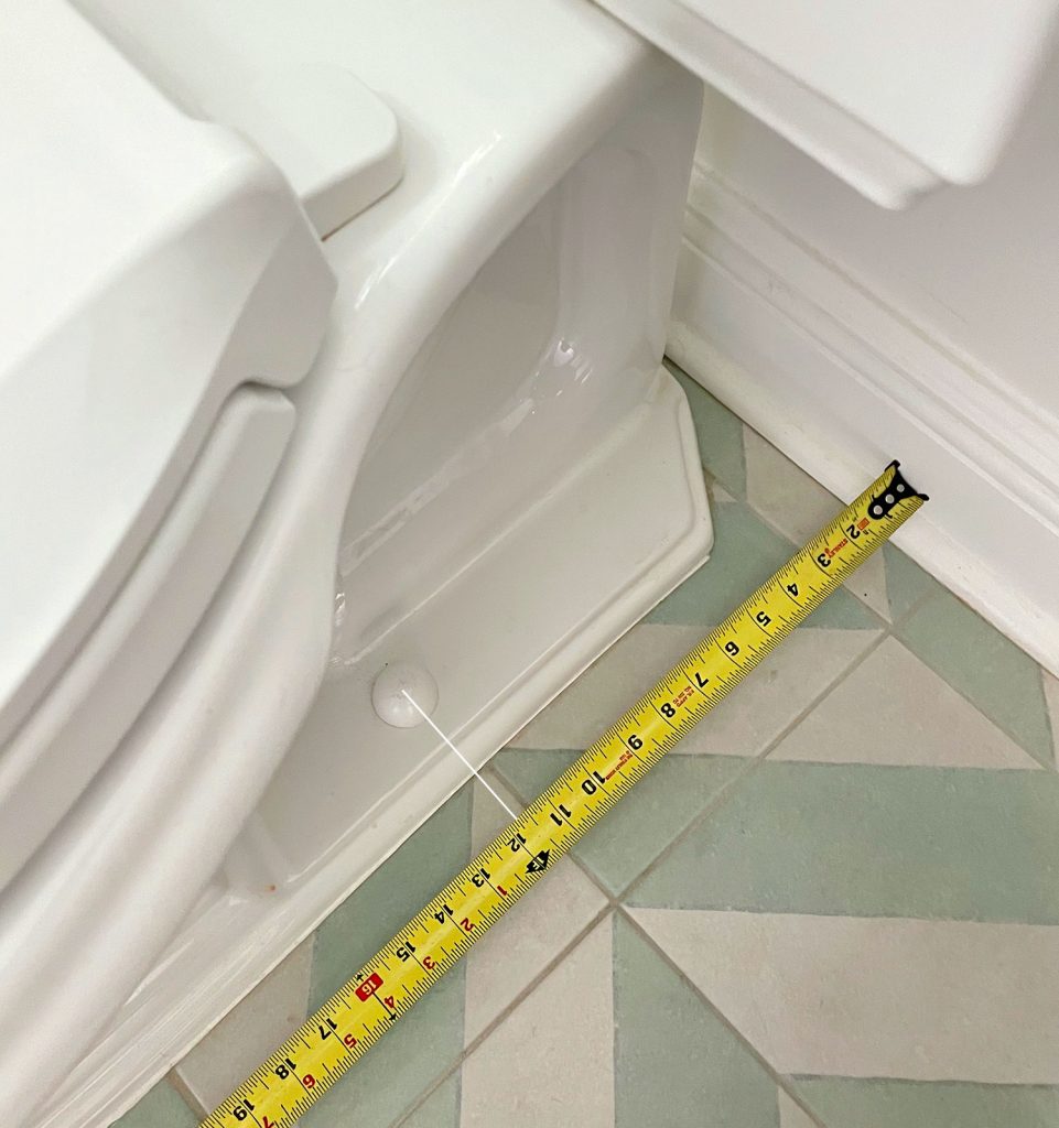 Tape Measure Taking Rough In Measurement By Toilet Bowl