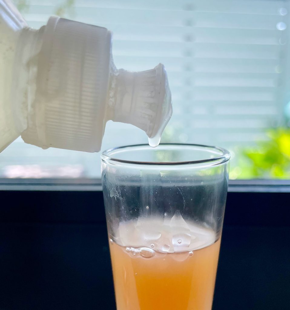 Dripping Dish Soap Into Apple Cider Vinegar For DIY Fruit Fly Trap