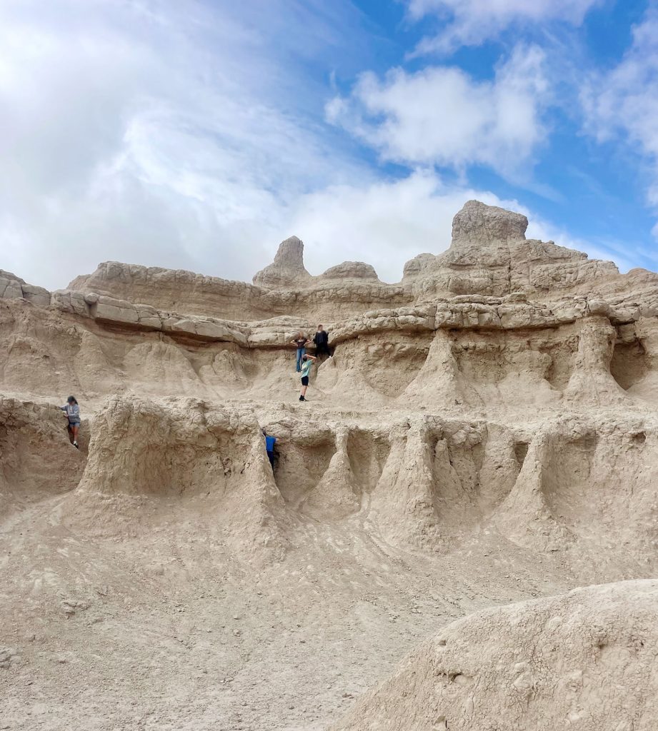 Kids Exploring Rock Formation In Badlands National Park