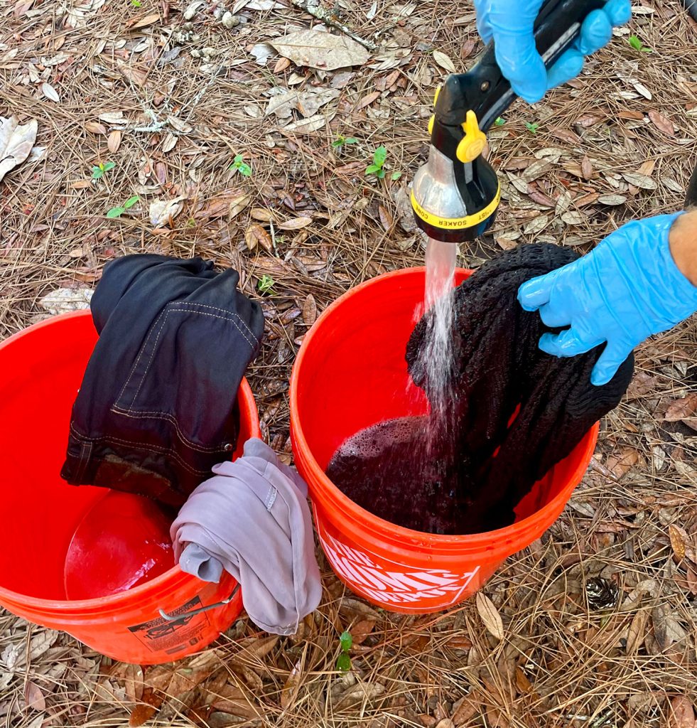 Rinsing Black Dyed Clothes Of Excess Rit Dye Into Bucket