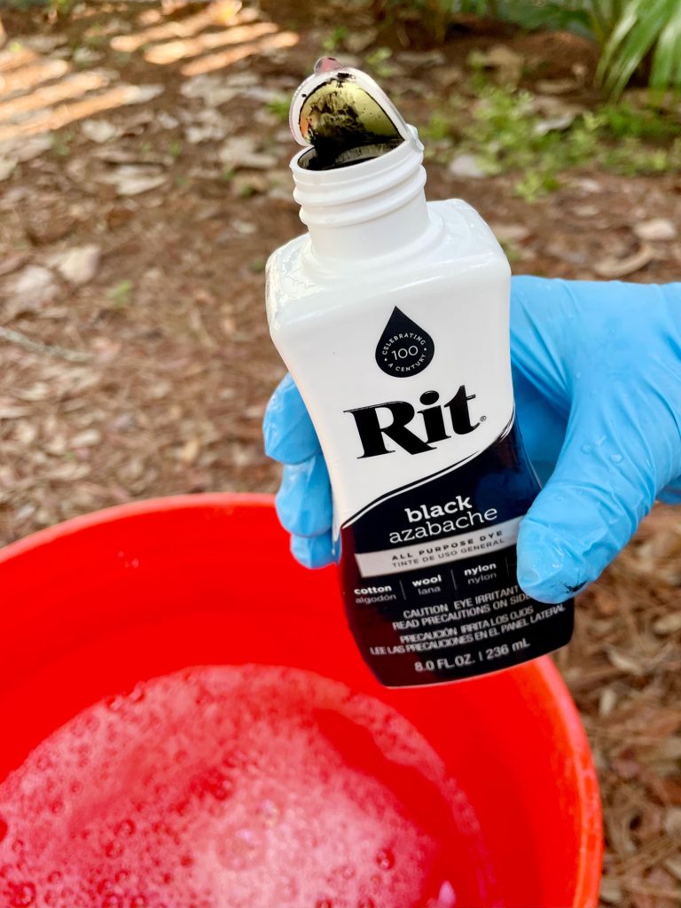 Bottle Of Black Rit Dye Over Bucket Of Hot Water