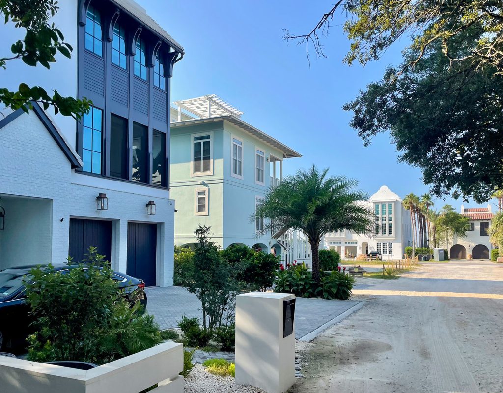 Multistory homes on street with palm trees