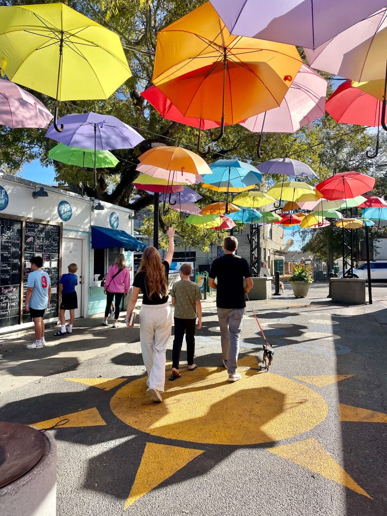 Des enfants marchant sous des parapluies brillants à Cash Alley à Ocean Springs Mississippi