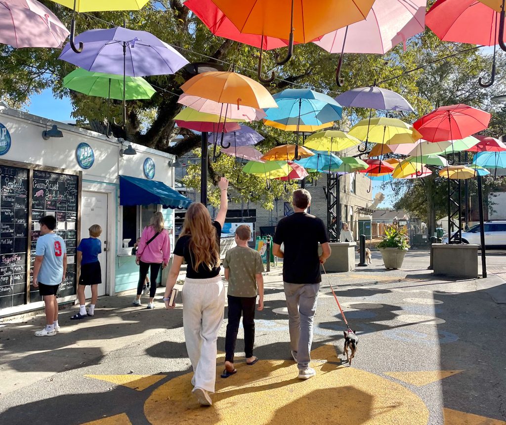 Des enfants marchant sous des parapluies brillants à Cash Alley à Ocean Springs Mississippi